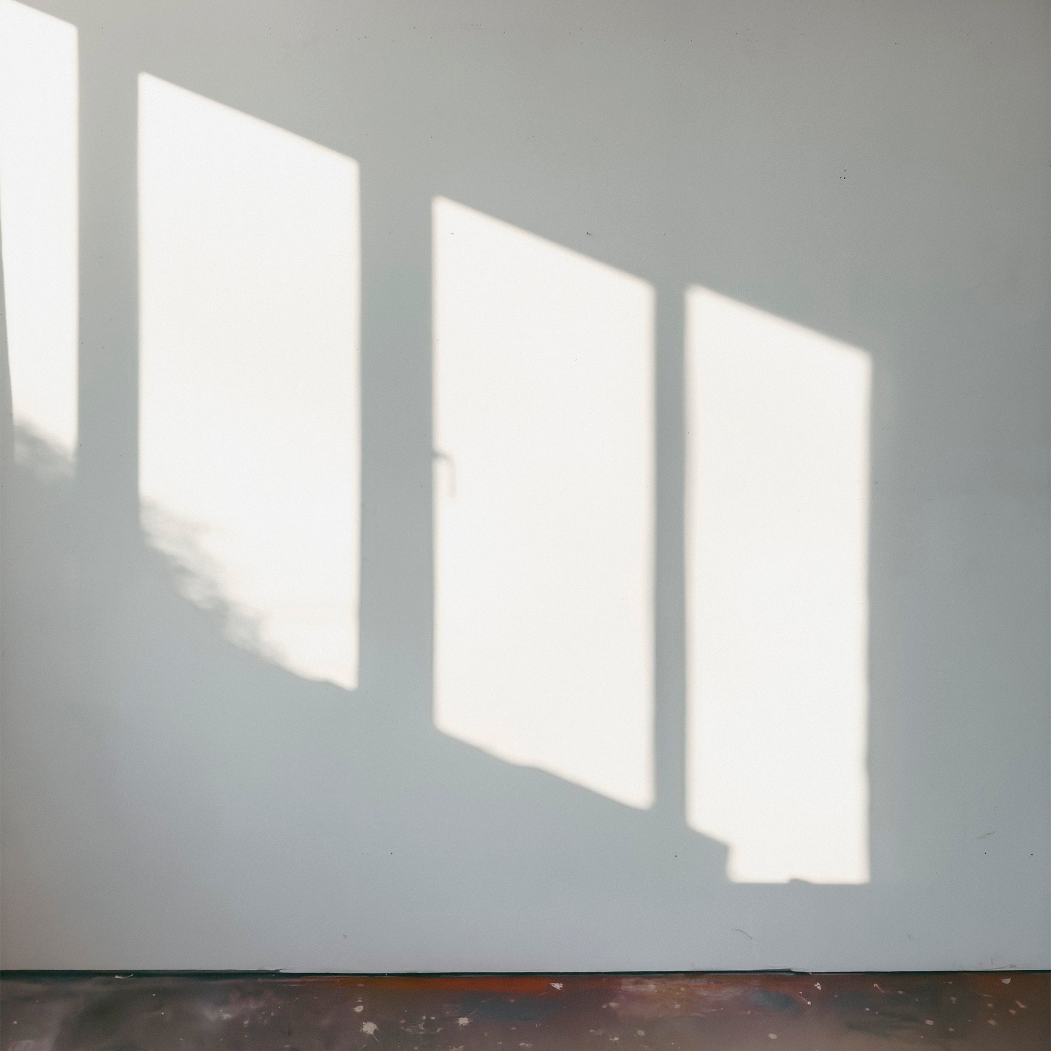 Lichteinfall und Schattenwurf auf weißer Wand im leeren Atelier, Baukunst Rene Kersting, Köln