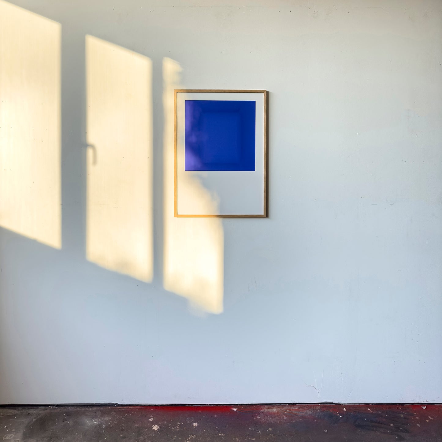 Kunstdruck im Bilderrahmen im Atelier, Motiv blau monochromer Raum, Titel IKB III - Edition