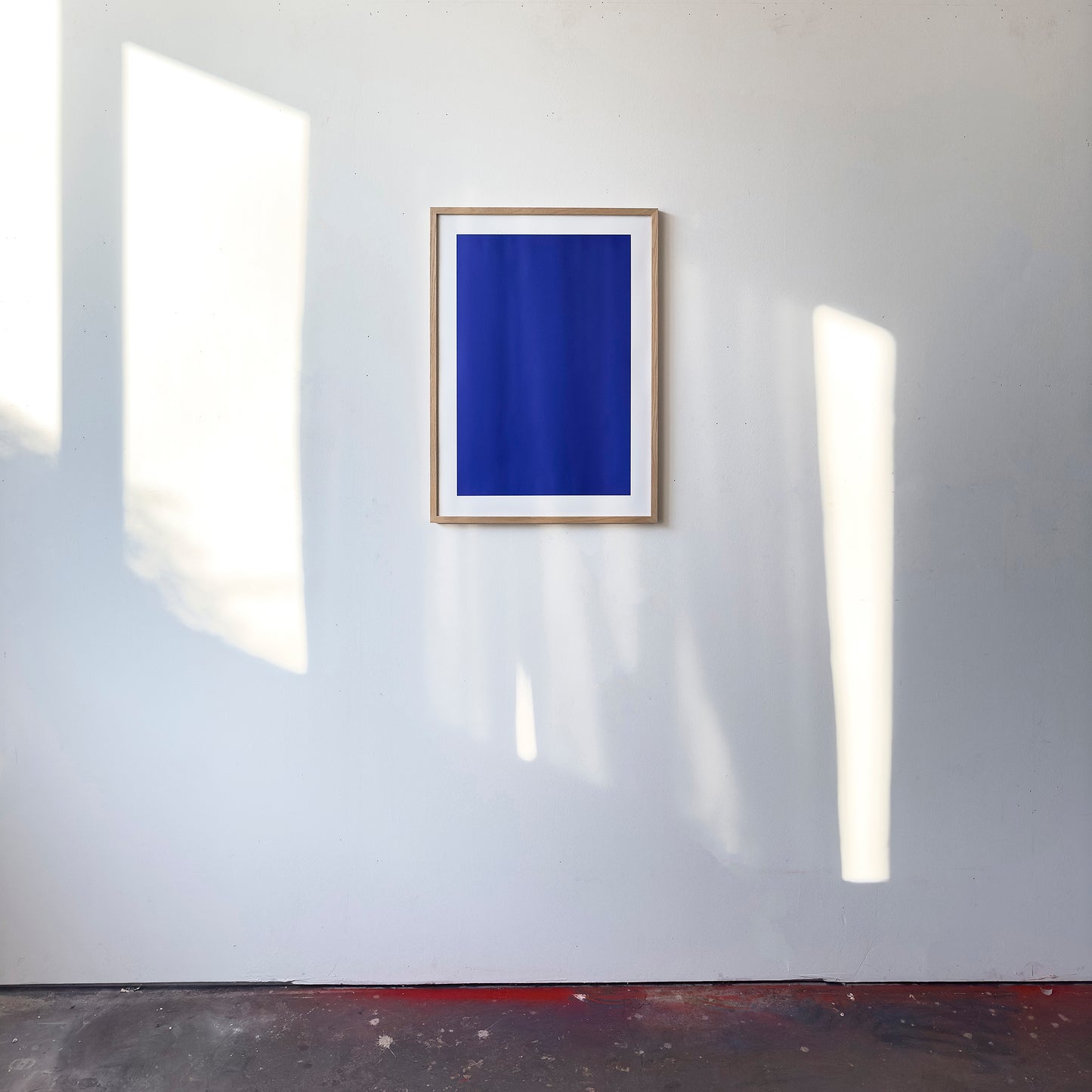 Kunstdruck im Bilderrahmen im Atelier, Motiv blau monochrome Welle, Titel IKB II